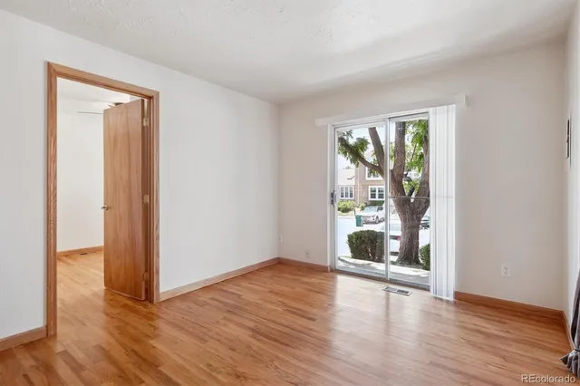 an empty room with wooden floor and windows