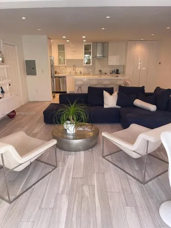 a large white kitchen with a large window and stainless steel appliances
