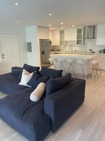 a living room with furniture and kitchen view