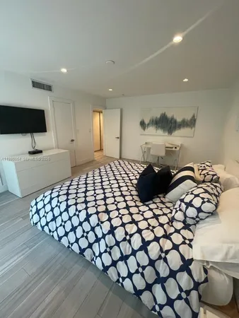 a large bed sitting in a bedroom next to a window with outer view of balcony