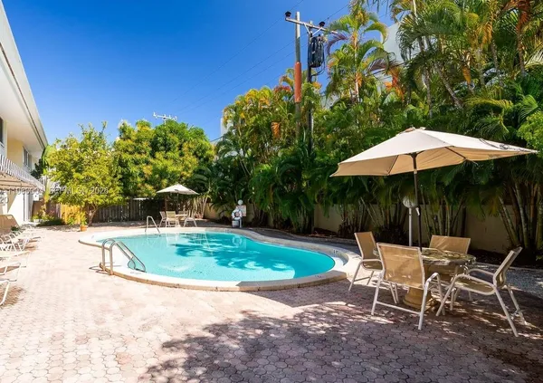 a view of backyard with outdoor seating and trees