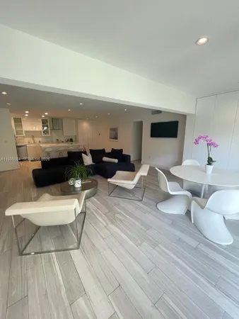 a living room with furniture and a view of kitchen