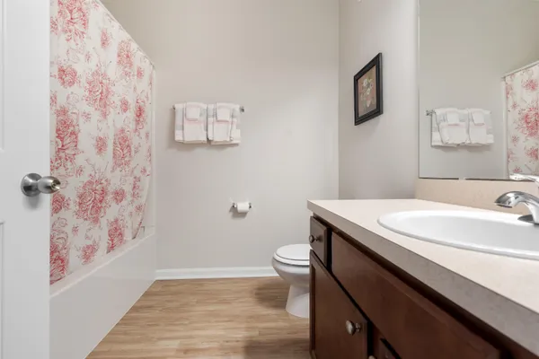 a bathroom with a granite countertop sink toilet and a mirror