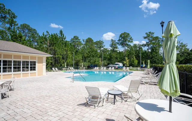 a view of a swimming pool with a patio and a yard