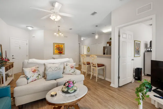 a living room with furniture kitchen and a chandelier