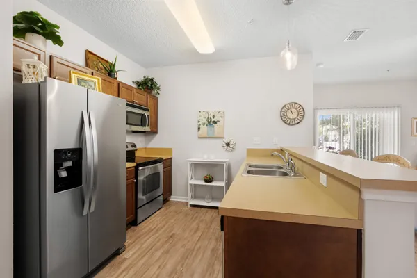 a kitchen with a refrigerator sink and wooden floor