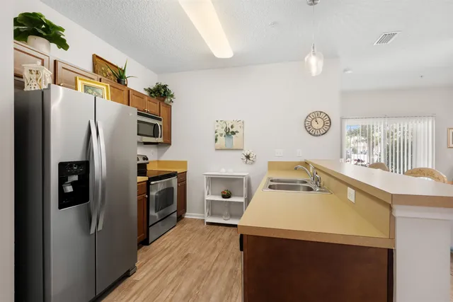 a kitchen with a refrigerator sink and wooden floor