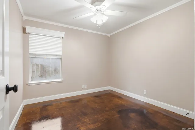 an empty room with a window and a fan