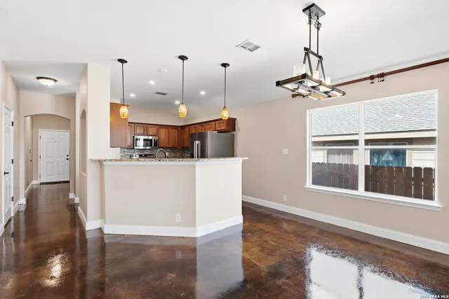 a living room with kitchen island furniture and a chandelier