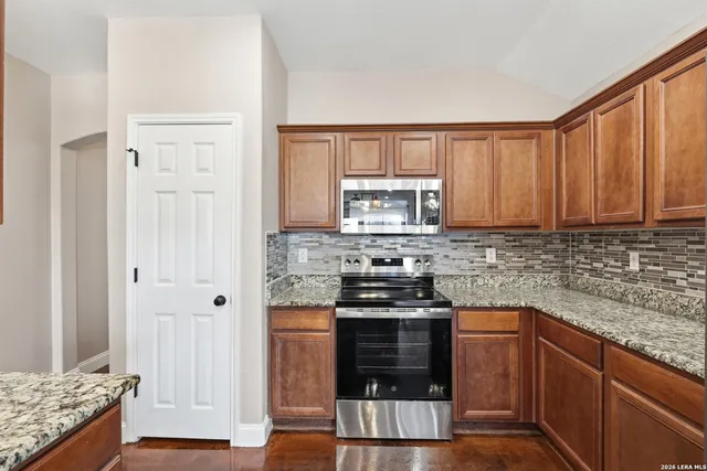 a kitchen with stainless steel appliances granite countertop a stove a sink and a microwave