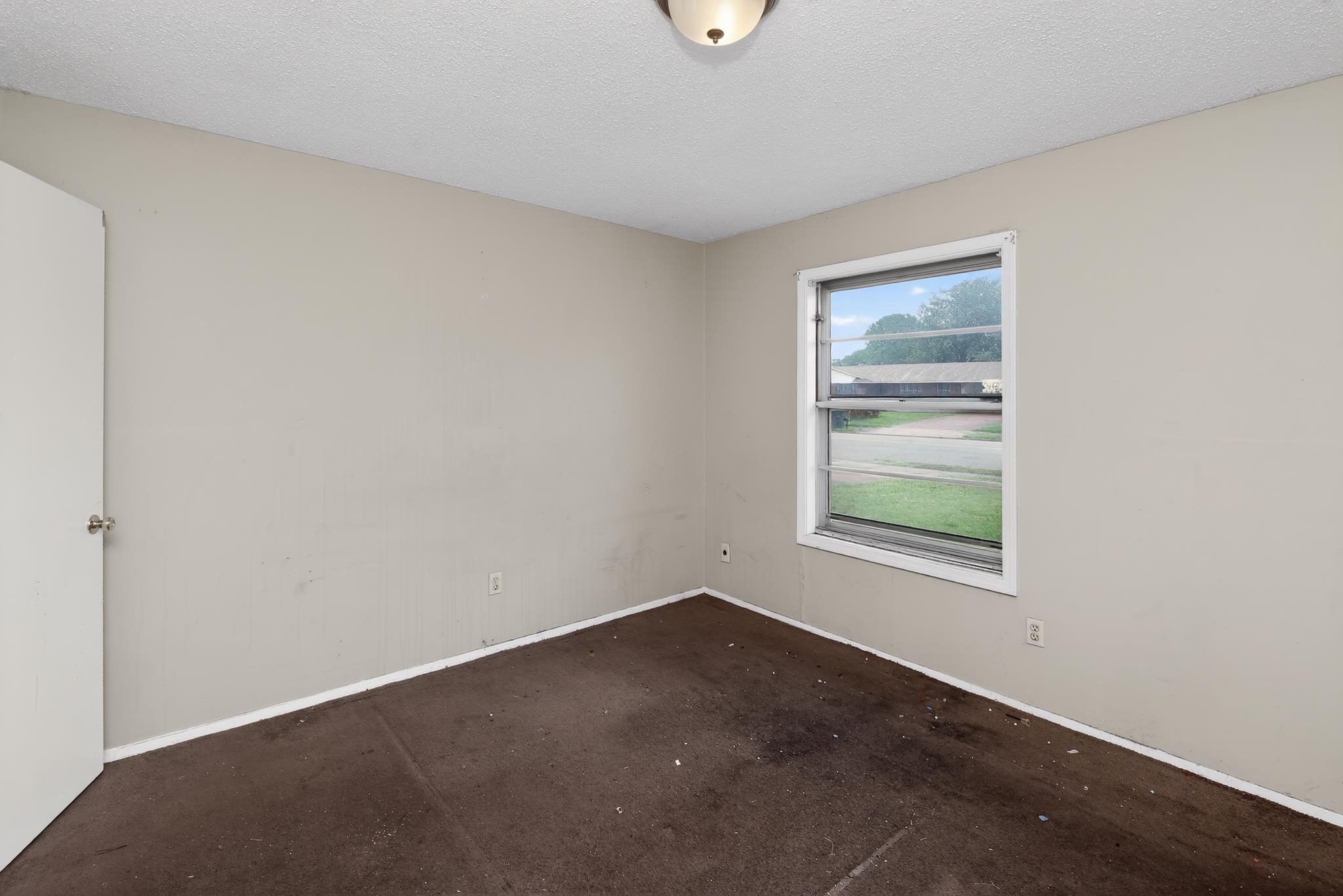 645 Parkrose Road Memphis, TN 38109 - Photo 30 of 32 Room featuring a single window, a ceiling-mounted light fixture, and a solid white door with a round knob