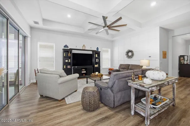 a living room with furniture a flat screen tv and a window