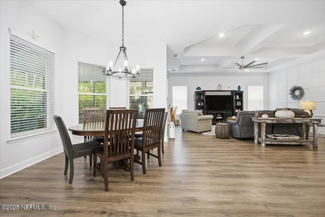 a view of a dining room with furniture a chandelier and wooden floor