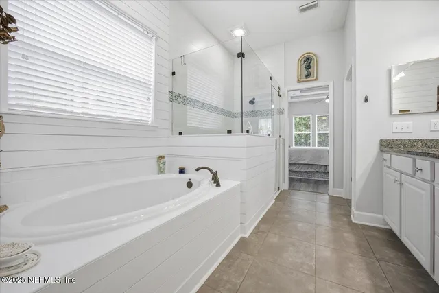 a spacious bathroom with a bathtub sink and mirror