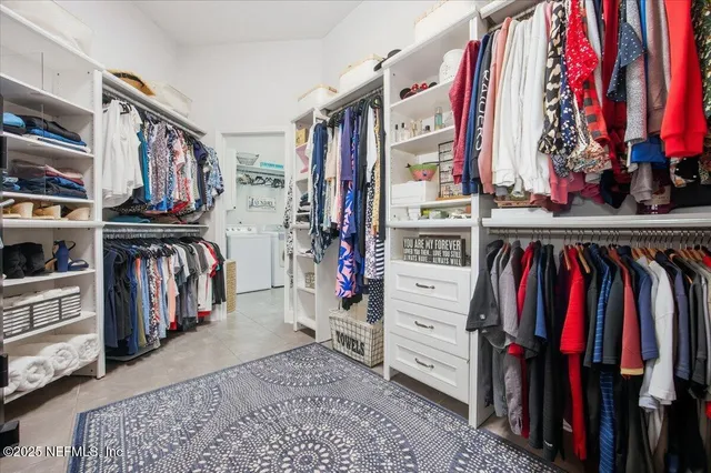 a view of walk in closet with clothes and shoes