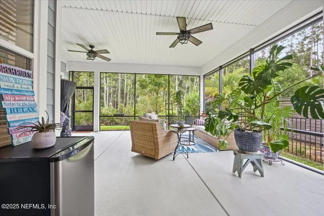 a living room with furniture and floor to ceiling windows
