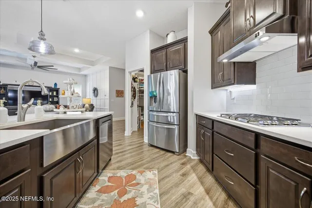 a kitchen with stainless steel appliances granite countertop a refrigerator a stove and a sink with cabinets