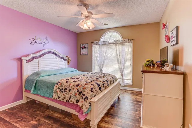 a spacious bedroom with a bed and a chandelier