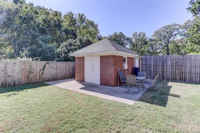 a view of a patio with table and chairs with wooden floor and fence