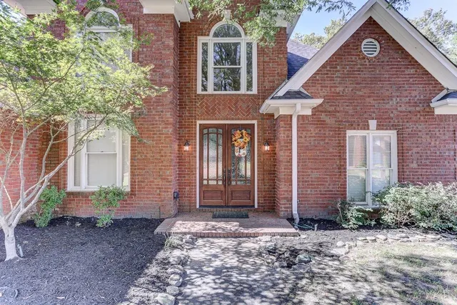a view of a brick house with large windows