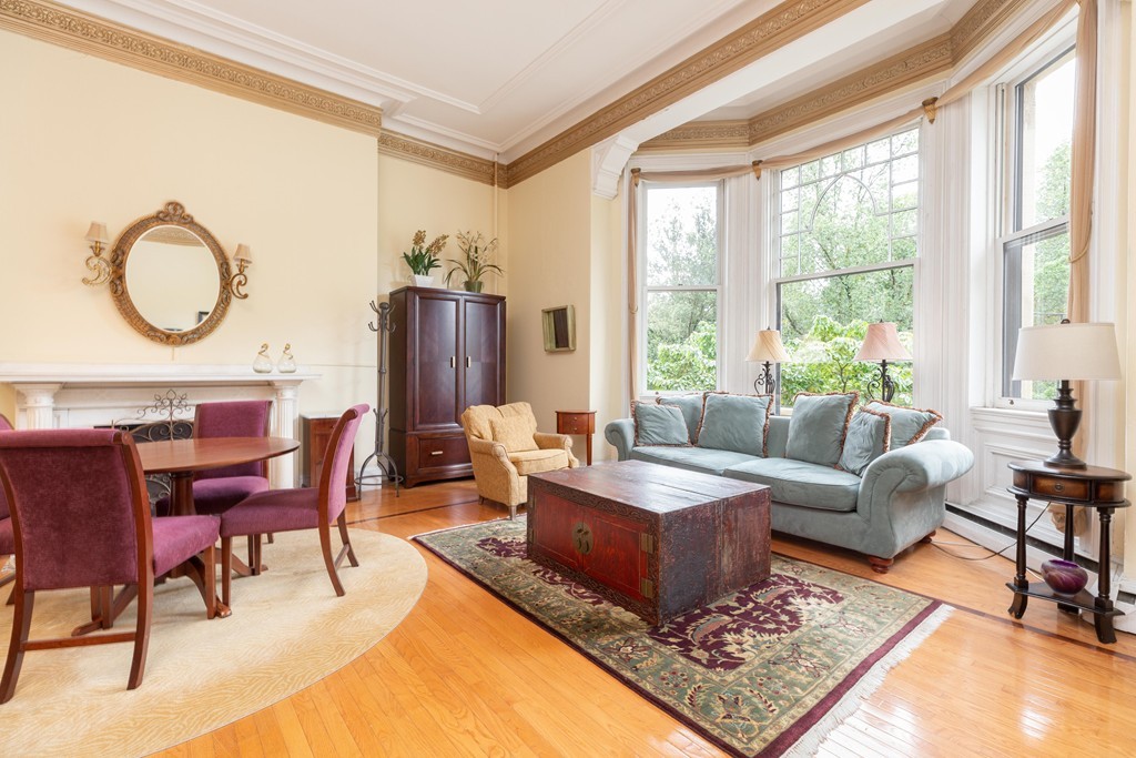 64 Commonwealth Avenue, Unit 3 Boston, MA 02116 - Photo 1 of 10 a living room with furniture a rug and a floor to ceiling window