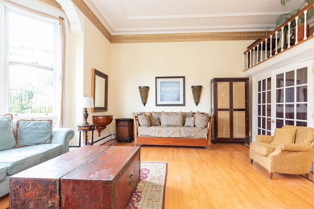 64 Commonwealth Avenue, Unit 3 Boston, MA 02116 - Photo 5 of 10 a living room with furniture and a dining table next to a window