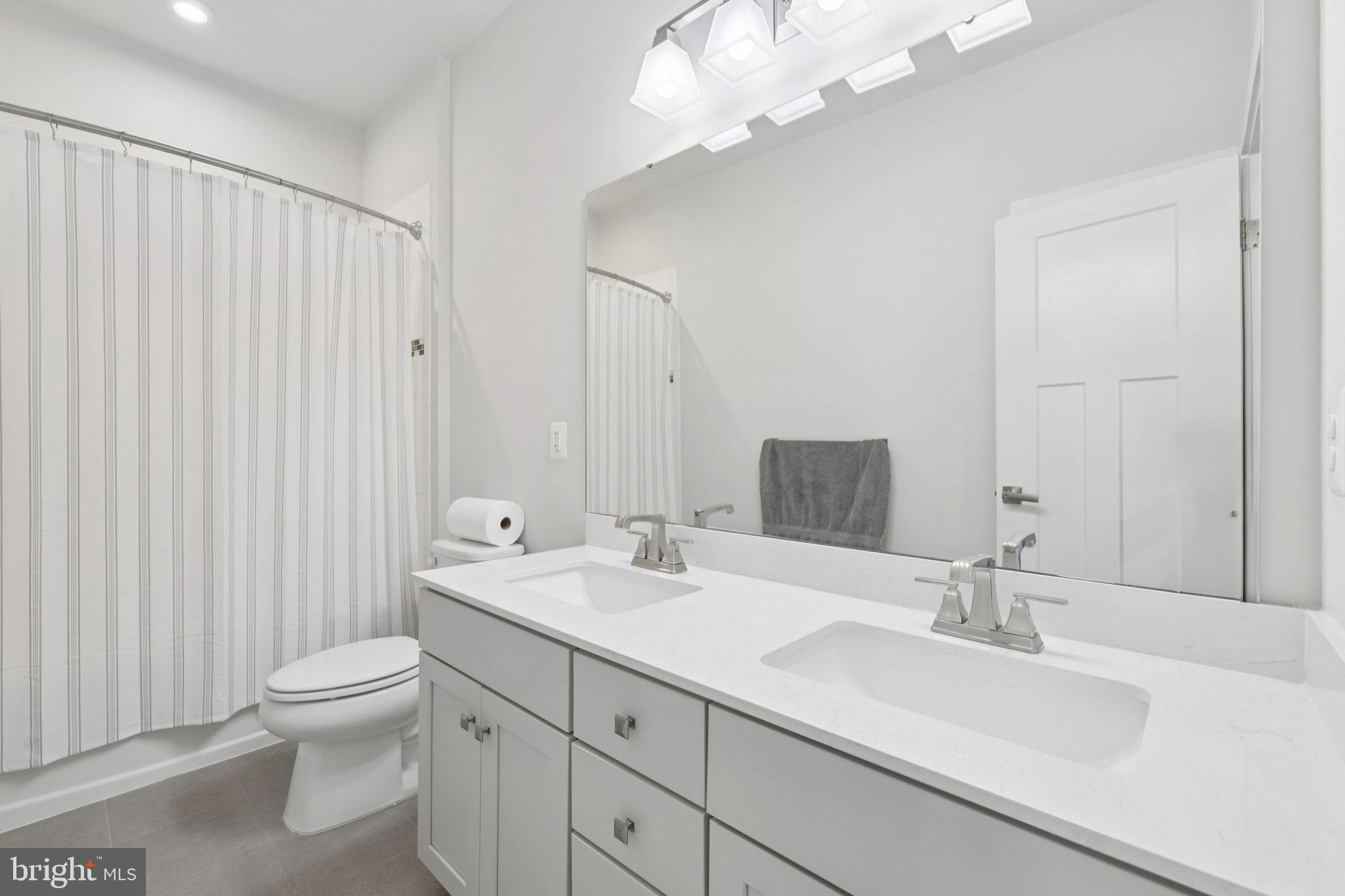 6604 River Birch Road Frederick, MD 21703 - Photo 37 of 58 a bathroom with a double vanity sink mirror and toilet