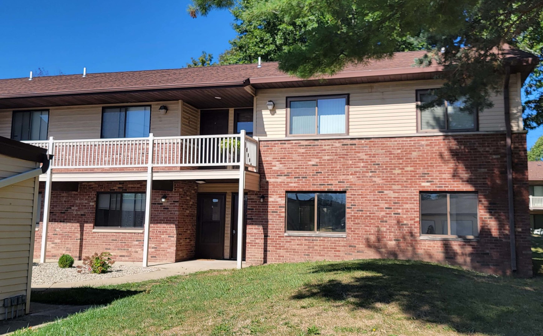 a view of a house with a yard and a large tree