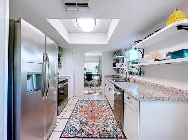 a kitchen with stainless steel appliances granite countertop a lot of counter space and wooden floor