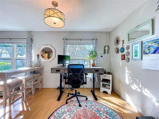 a view of a workspace room with furniture and a window