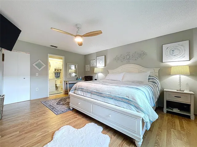 a spacious bedroom with a bed and a flat screen tv