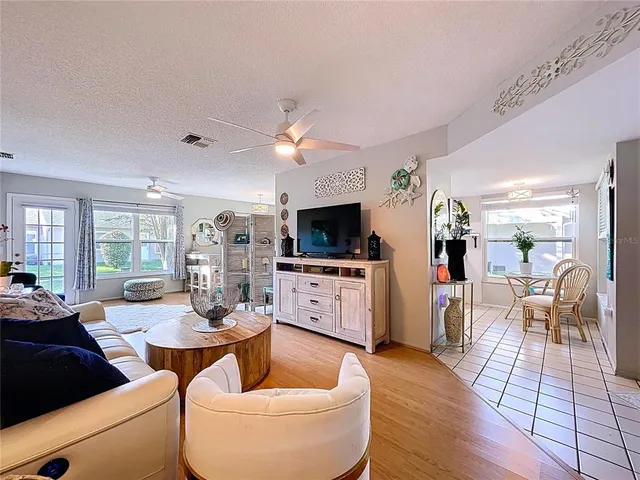 a living room with furniture a flat screen tv and a floor to ceiling window