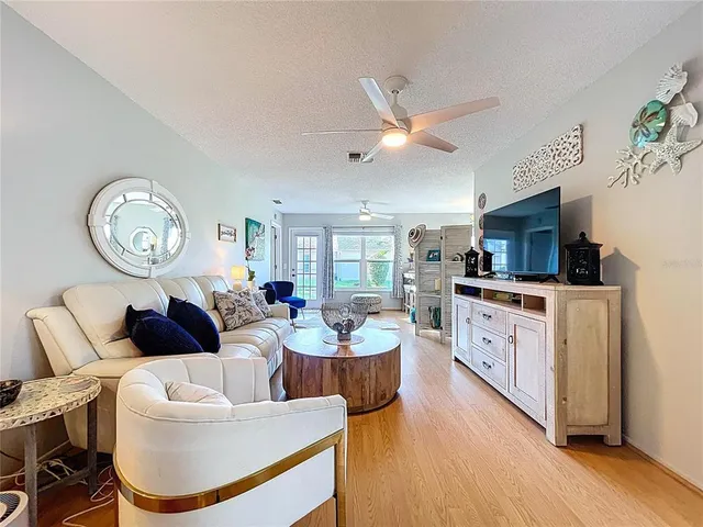 a living room with furniture a large window and kitchen view