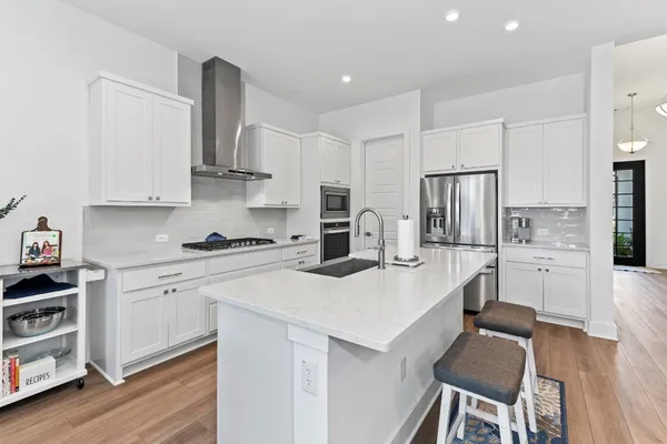 a kitchen with stainless steel appliances kitchen island granite countertop a sink a stove a microwave a counter space and cabinets