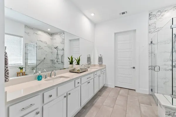 a bathroom with a double vanity sink and a shower