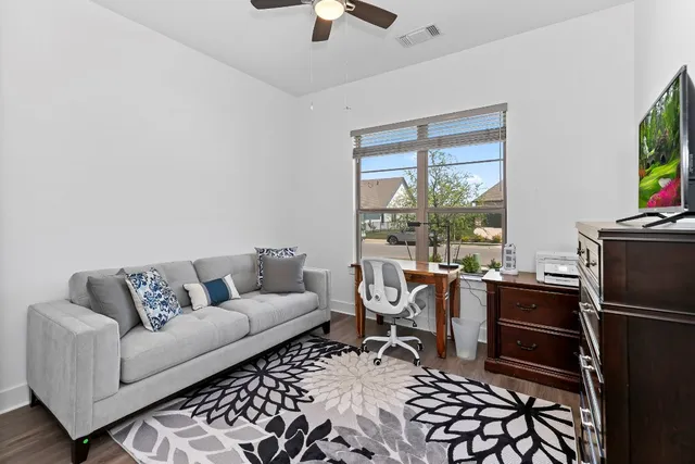 a view of a room with wooden floor lounge chair and windows