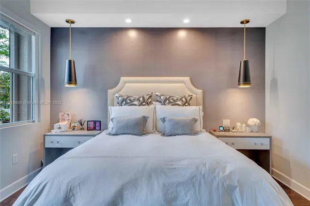 a bedroom with a bed and a large window