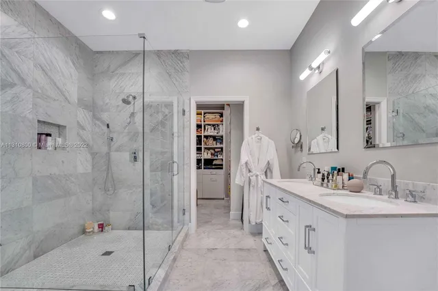 a bathroom with a double vanity sink mirror and shower