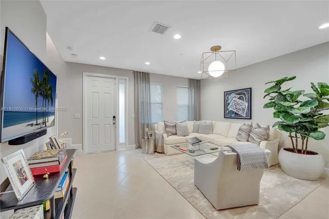 a living room with furniture flowerpot and a chandelier