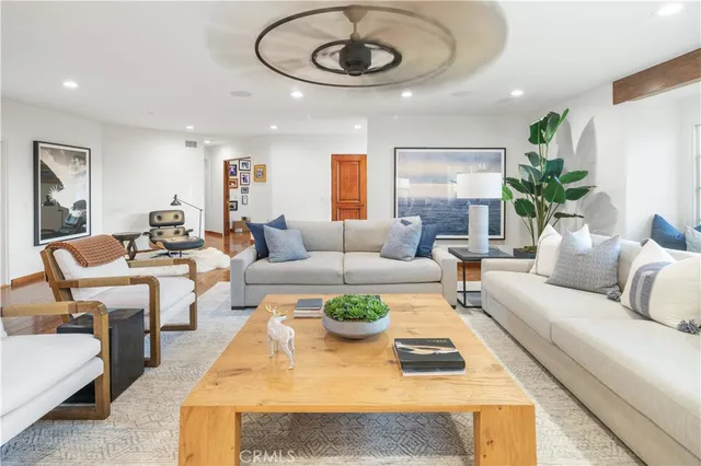 a living room with furniture potted plant and a large window