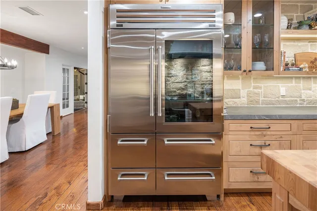 a kitchen with a refrigerator and white cabinets