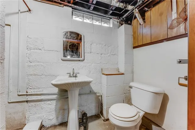 a bathroom with a toilet a sink and mirror