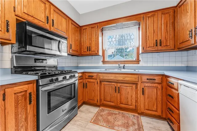 a kitchen with stainless steel appliances granite countertop a stove a sink and a microwave