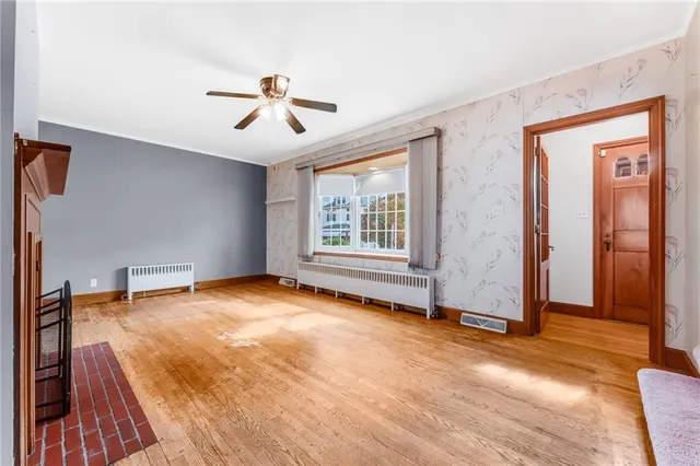an empty room with windows and ceiling fan