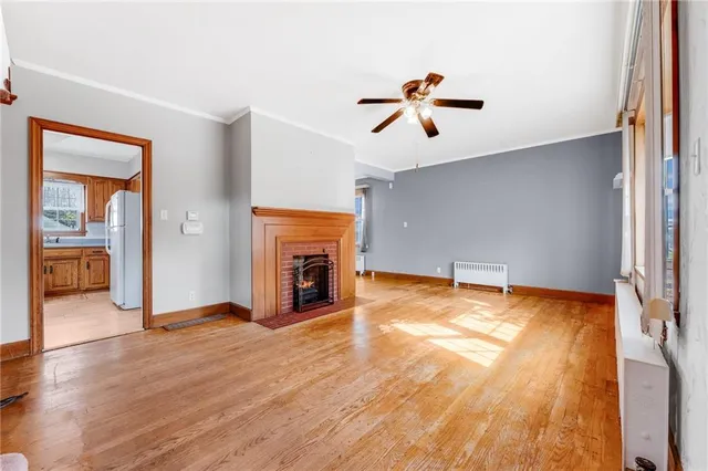 a view of empty room with wooden floor and fireplace