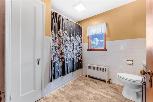 a bathroom with a toilet and a shower curtain
