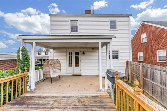 a view of house with wooden deck and furniture