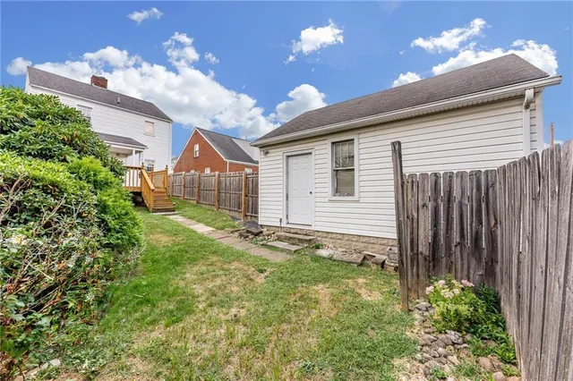 a view of a house with a small yard and potted plants