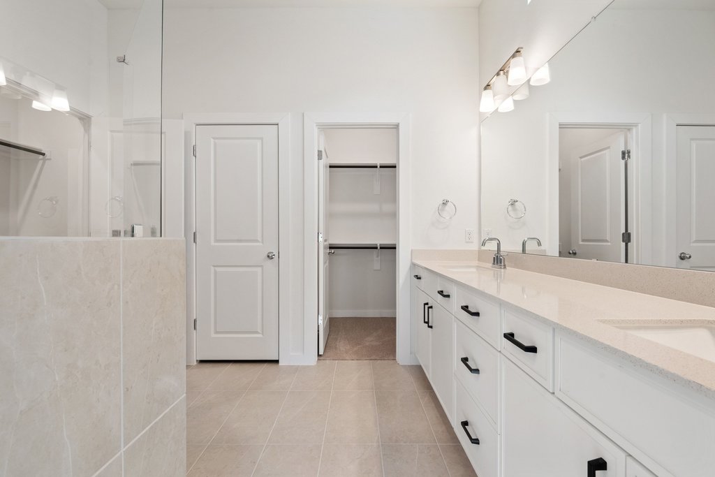 2205 Cento Walk Round Rock, TX 78664 - Photo 10 of 32 Bathroom featuring double vanity, a walk in shower, light tile patterned floors, and a spacious closet