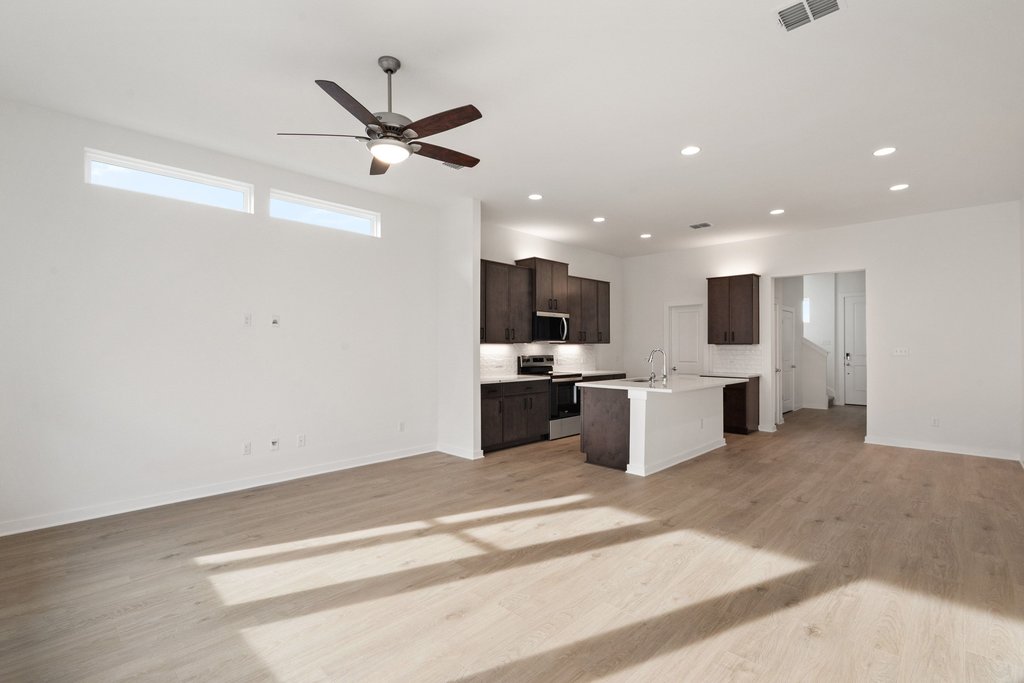 2205 Cento Walk Round Rock, TX 78664 - Photo 31 of 32 Kitchen featuring open floor plan, stainless steel appliances, a kitchen island with sink, light wood-style floors, and recessed lighting